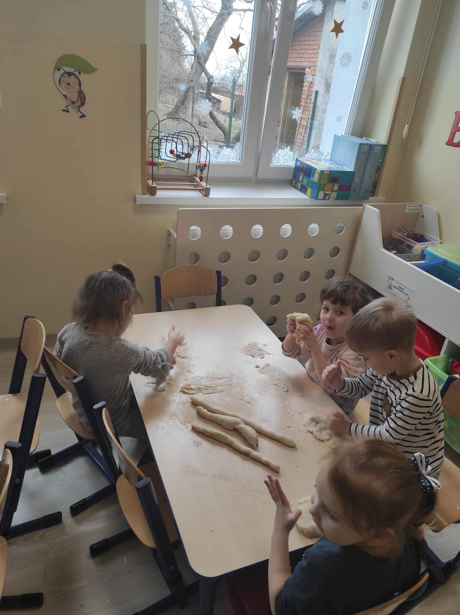 Dzieci z biedronek lepią z masy solnej przy stolikach
