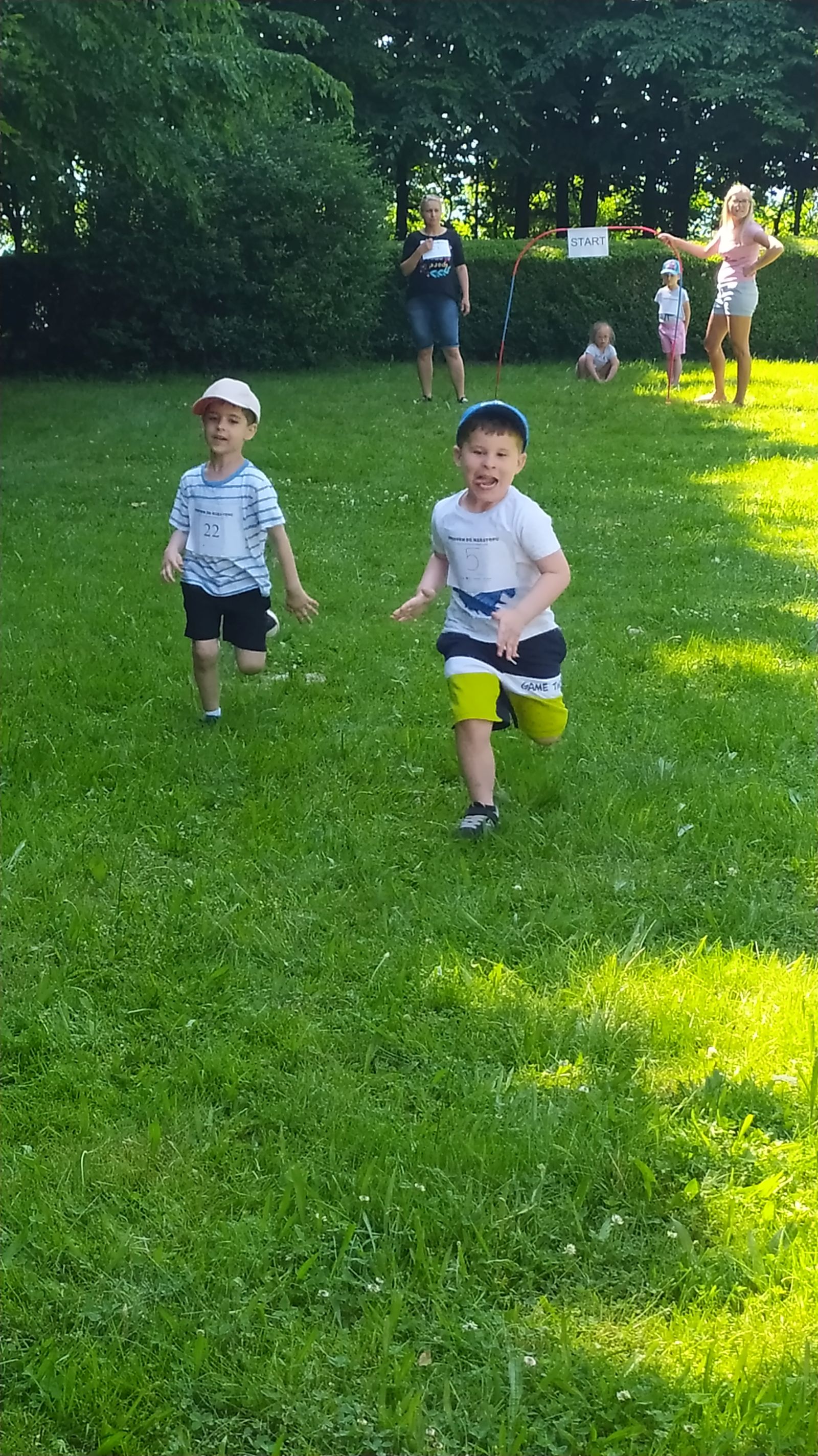 dwaj chłopcy biegną do mety