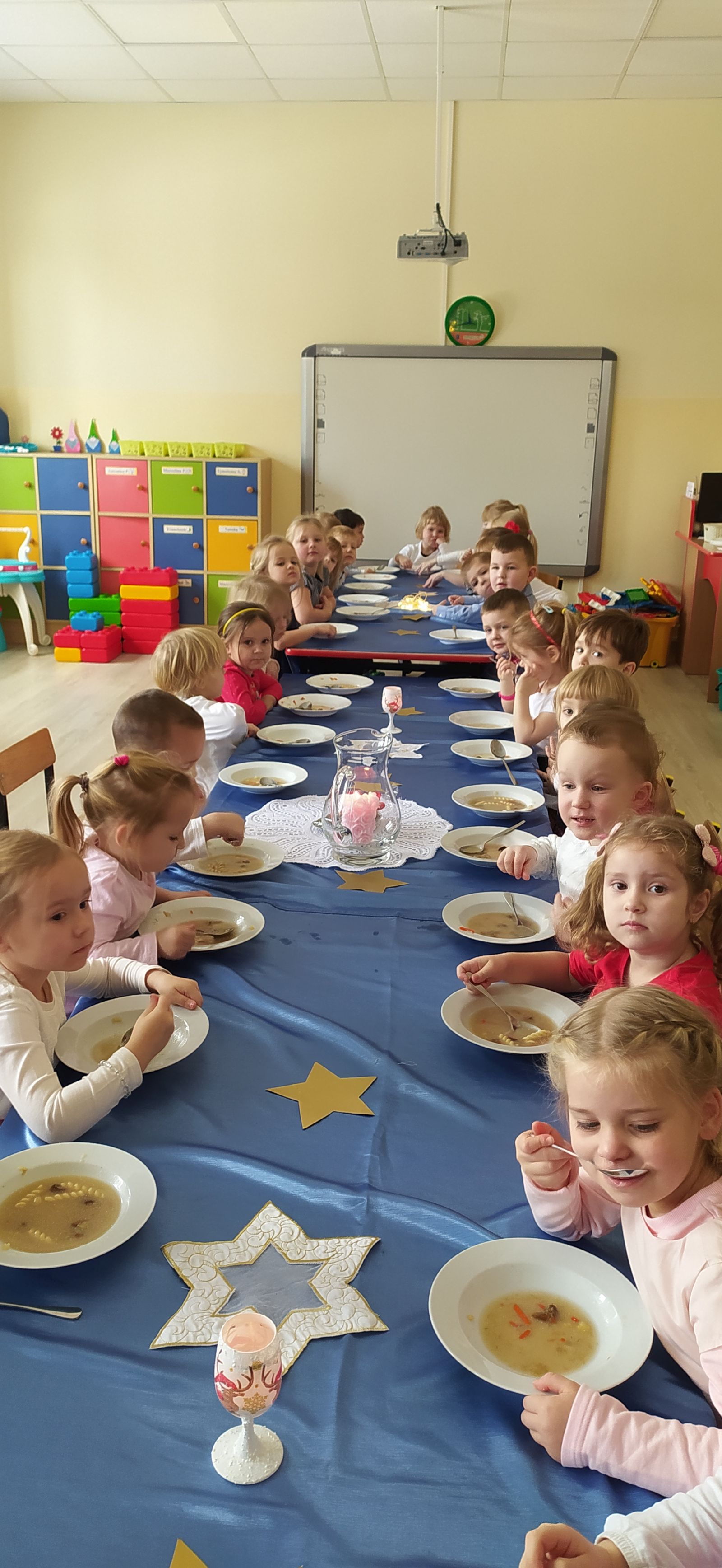 Wigilia dzieci siedzą przy stolikach spożywają posiłek
