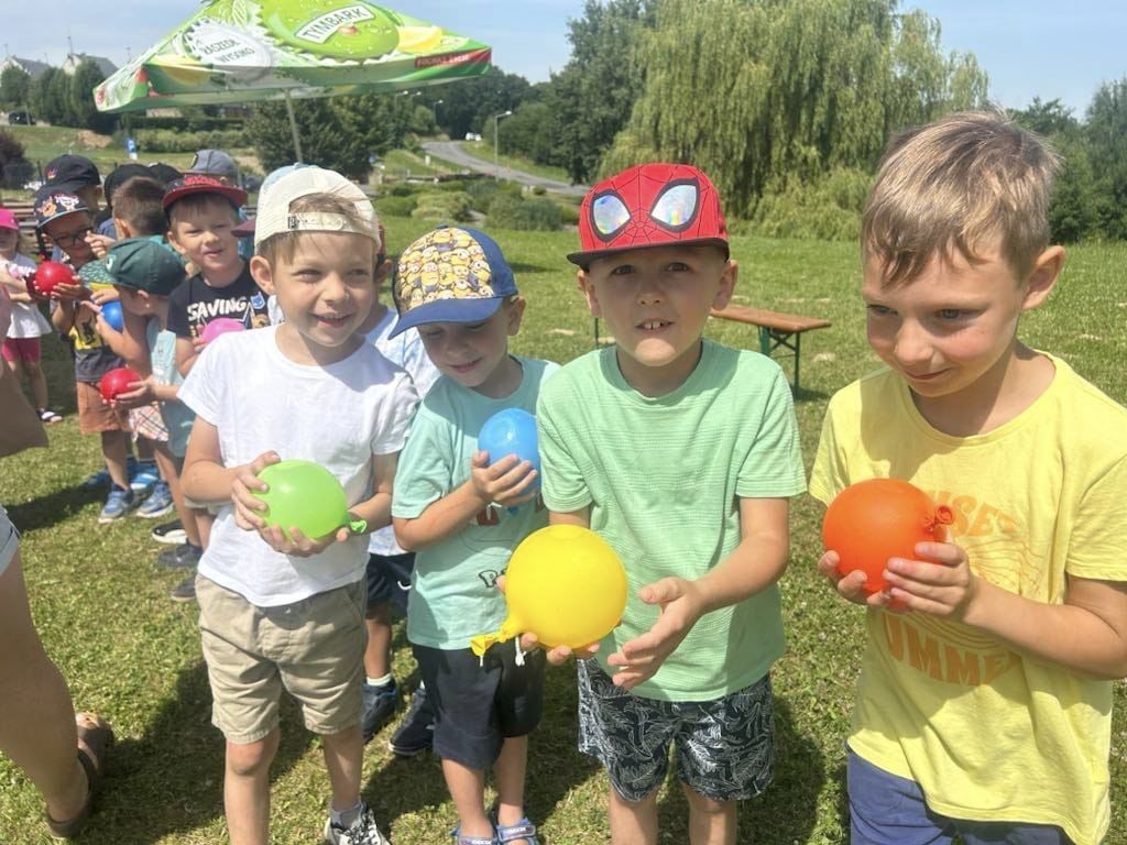 chłopcy stoją z balonami z wodą