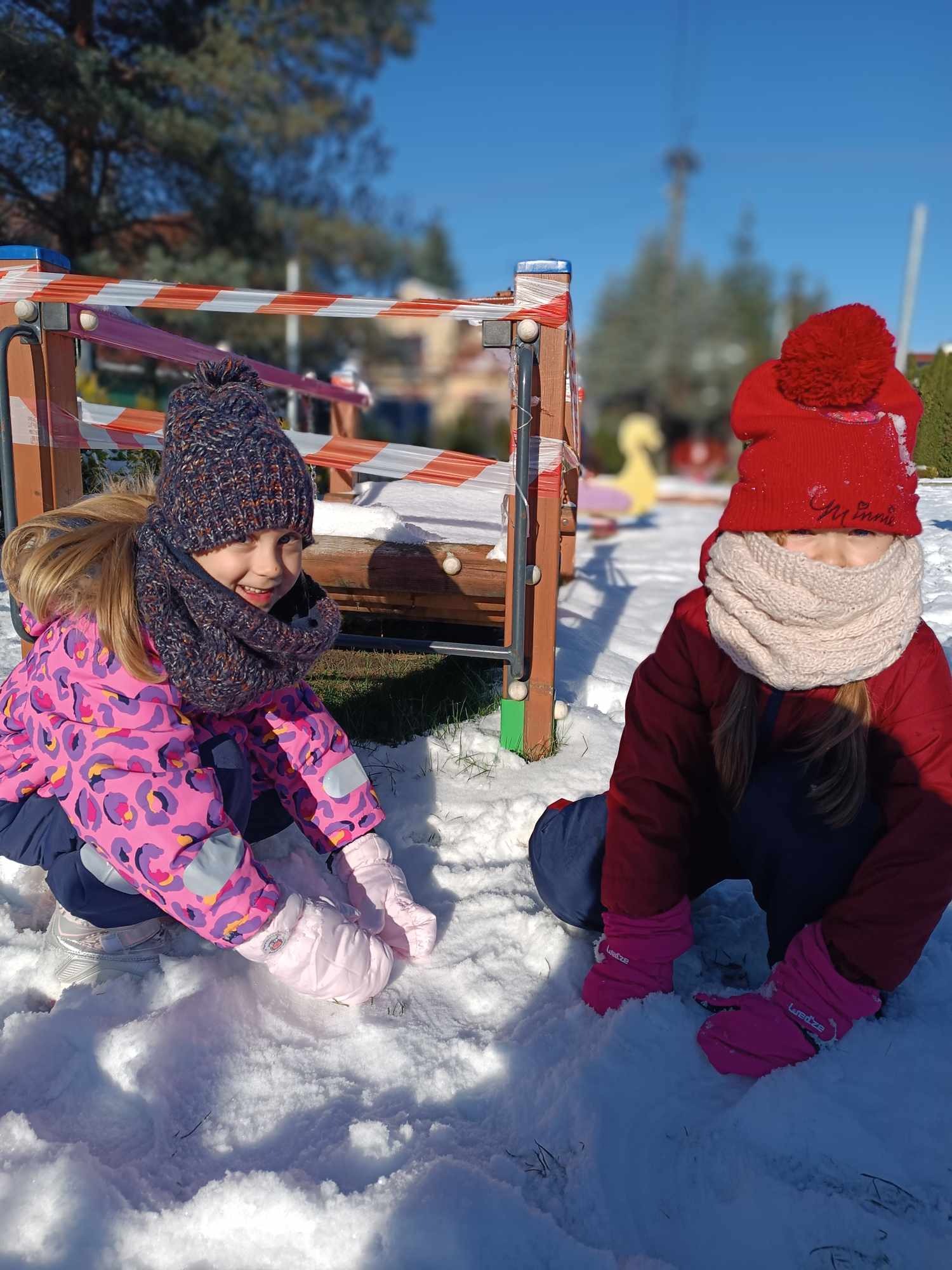 dziewczynki bawią się śniegiem