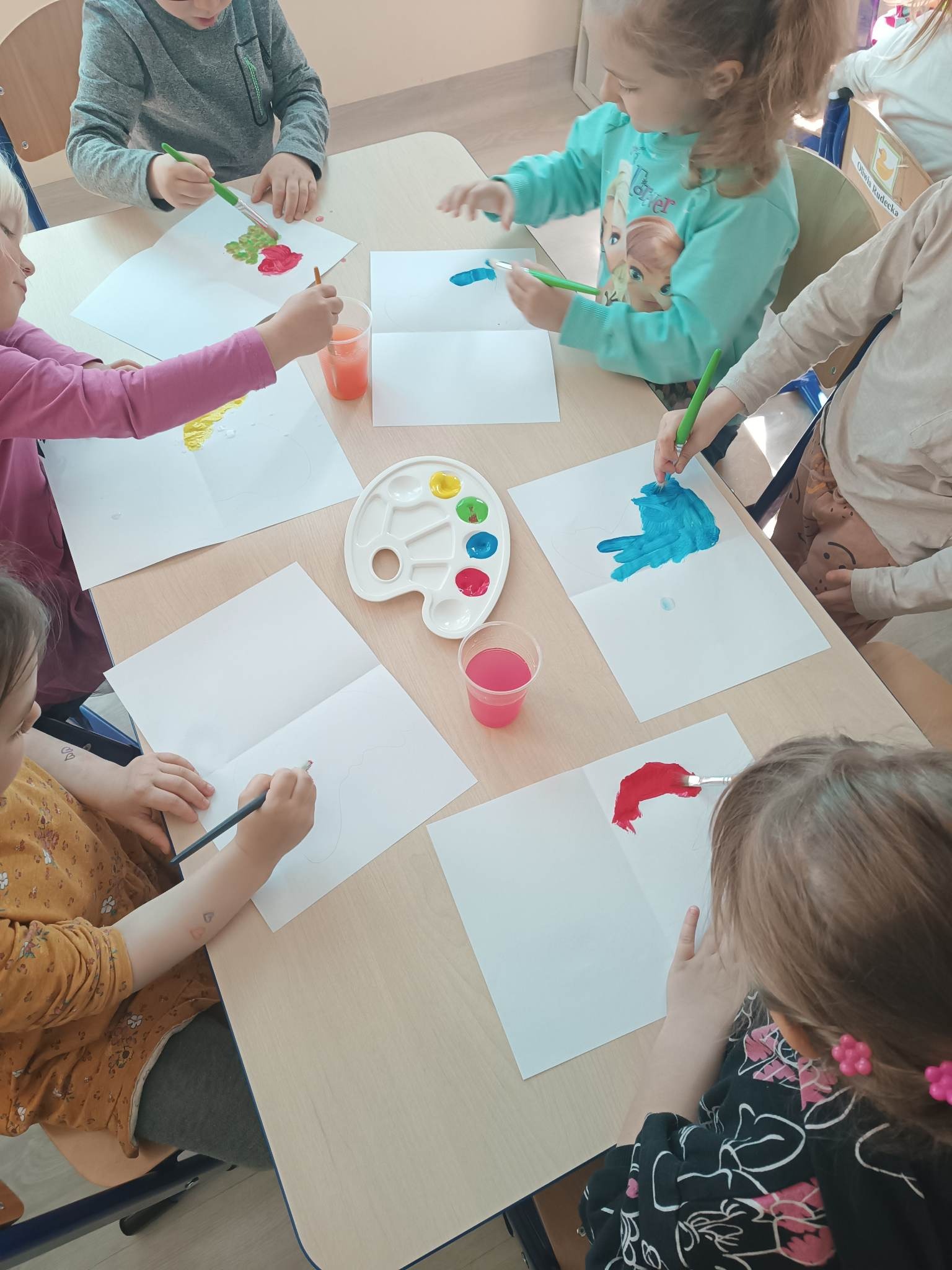 dzieci malują farbami przy stoliku