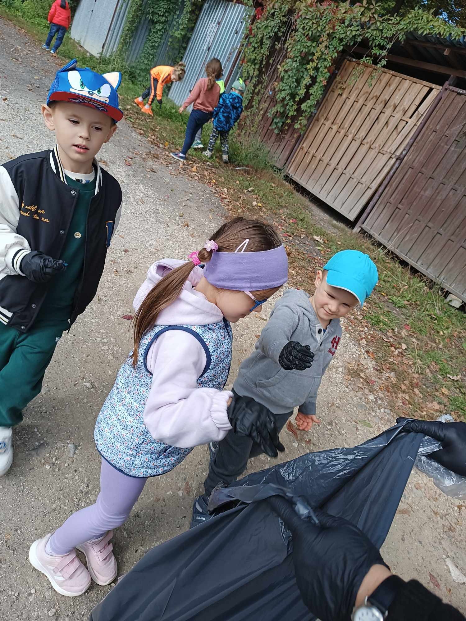 dzieci zbierają pozostawione śmieci