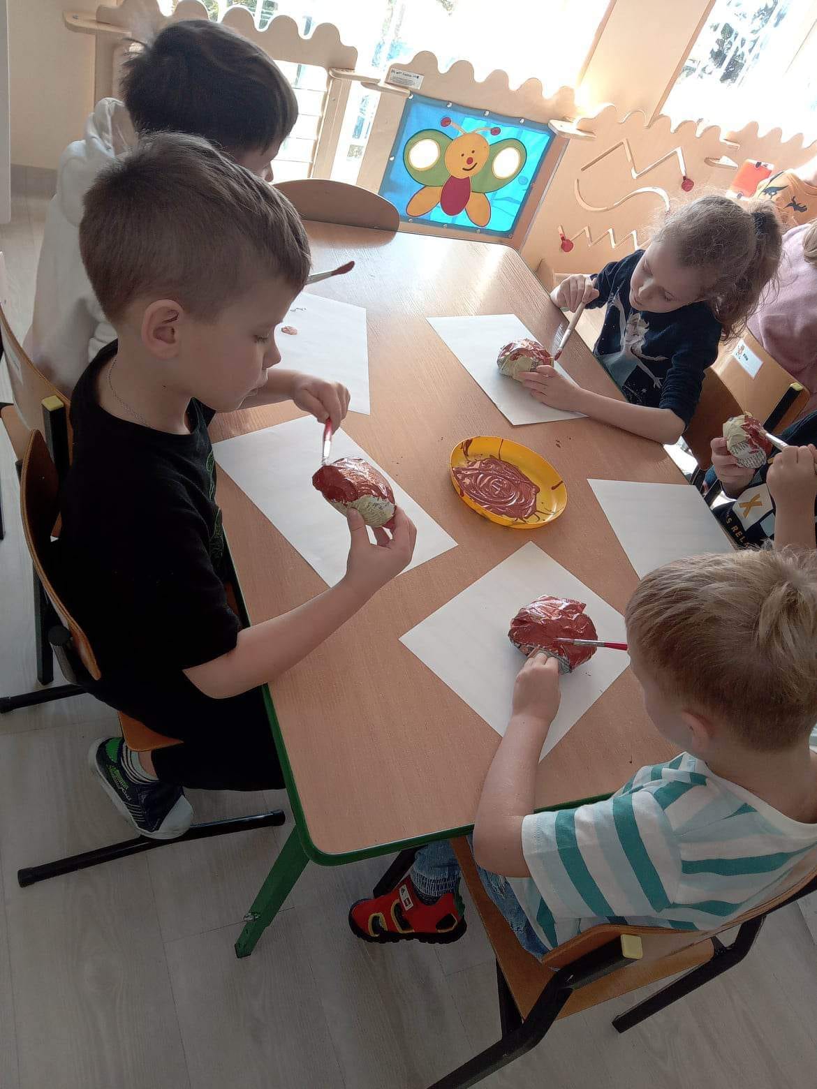 tygryski malują papierowe pączki farbą brązową