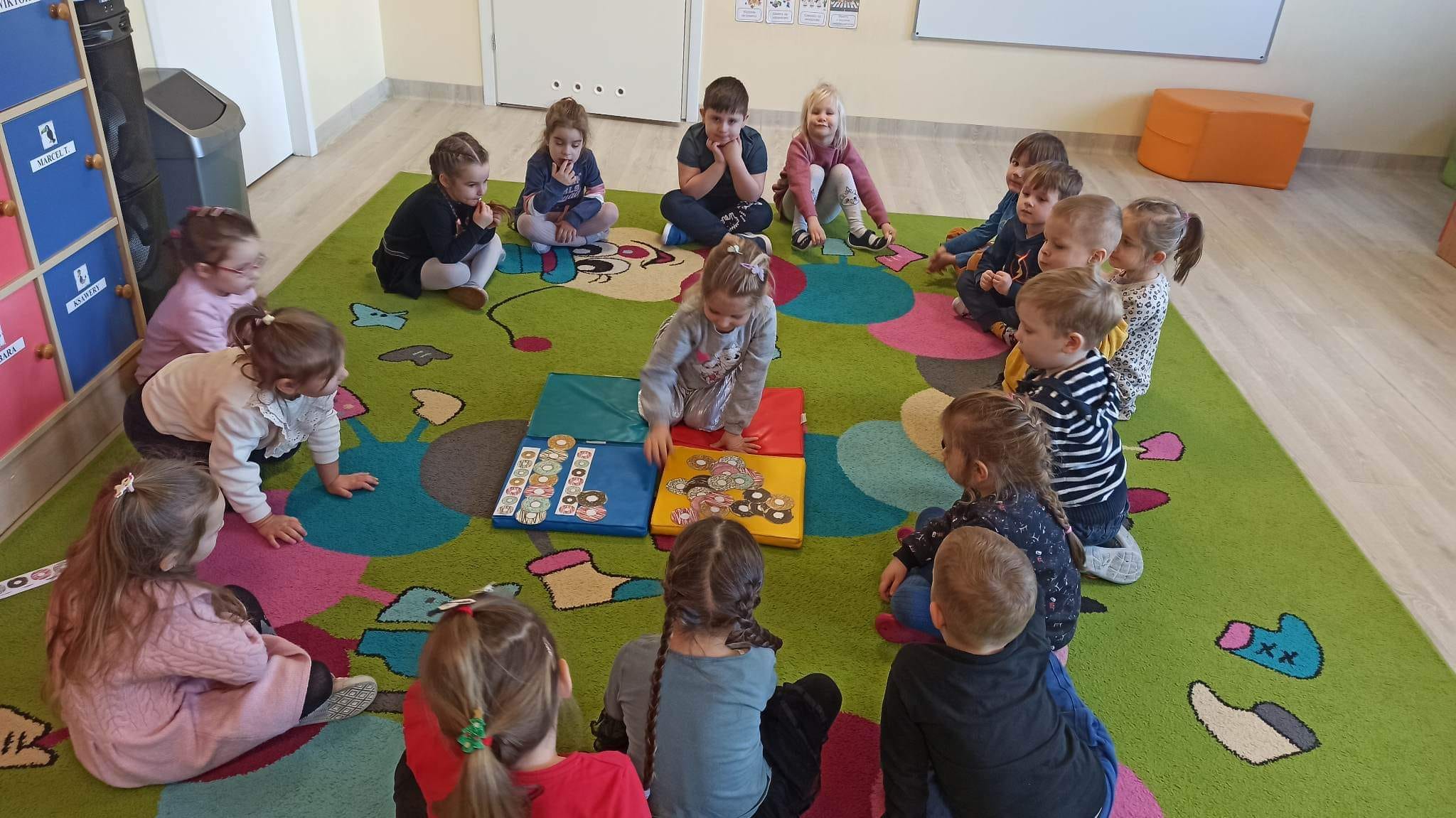 żabki siedzą w kole oglądają różne pączki